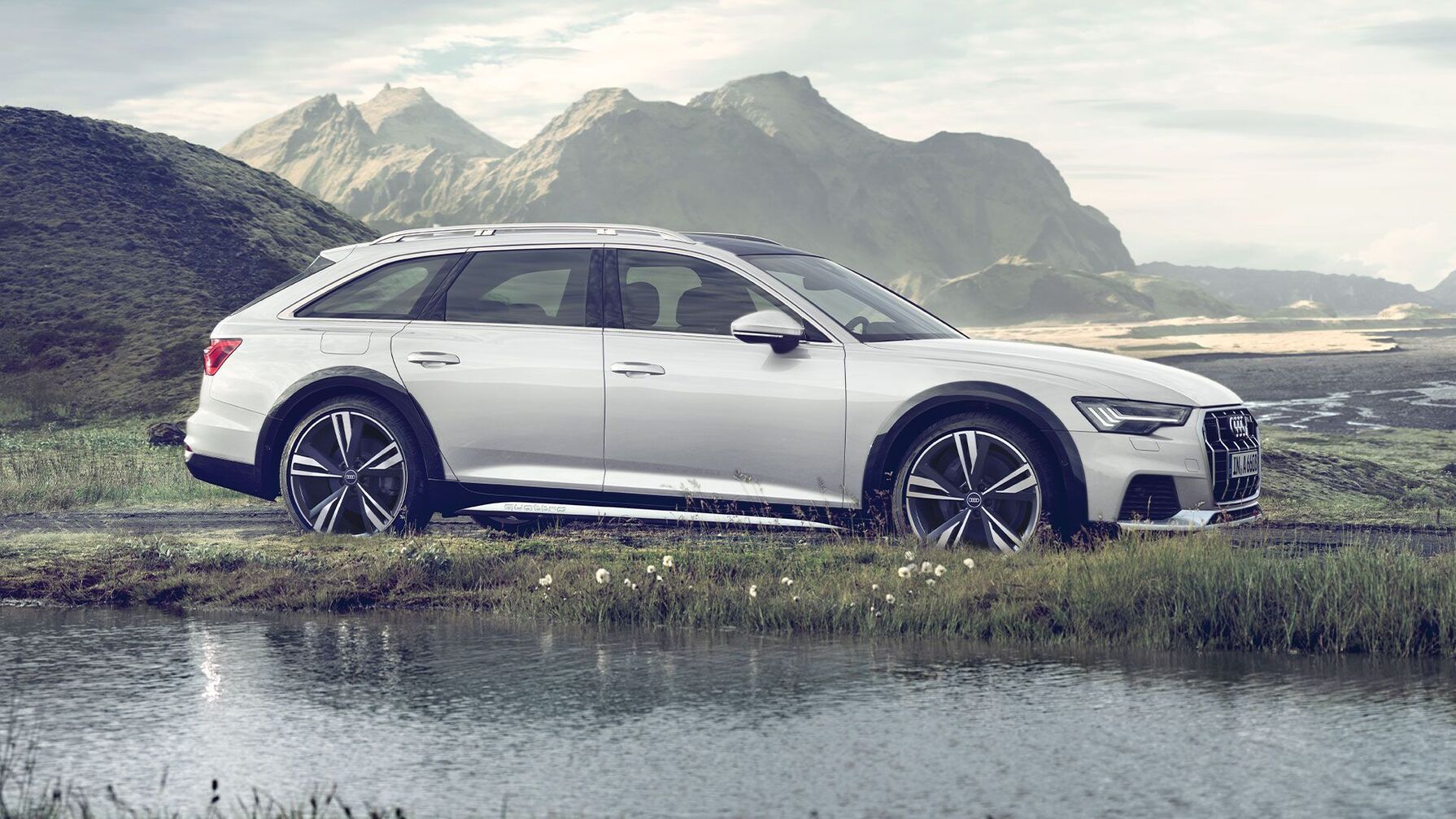 A6 allroad quattro in weiß vor einem Fluss und Bergen